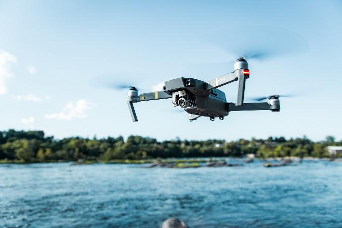 black DJI Mavi quadcopter near body of water